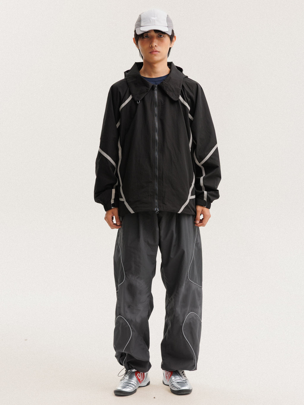 Black jacket — front view with the zip closed and curved sleeve panels visible