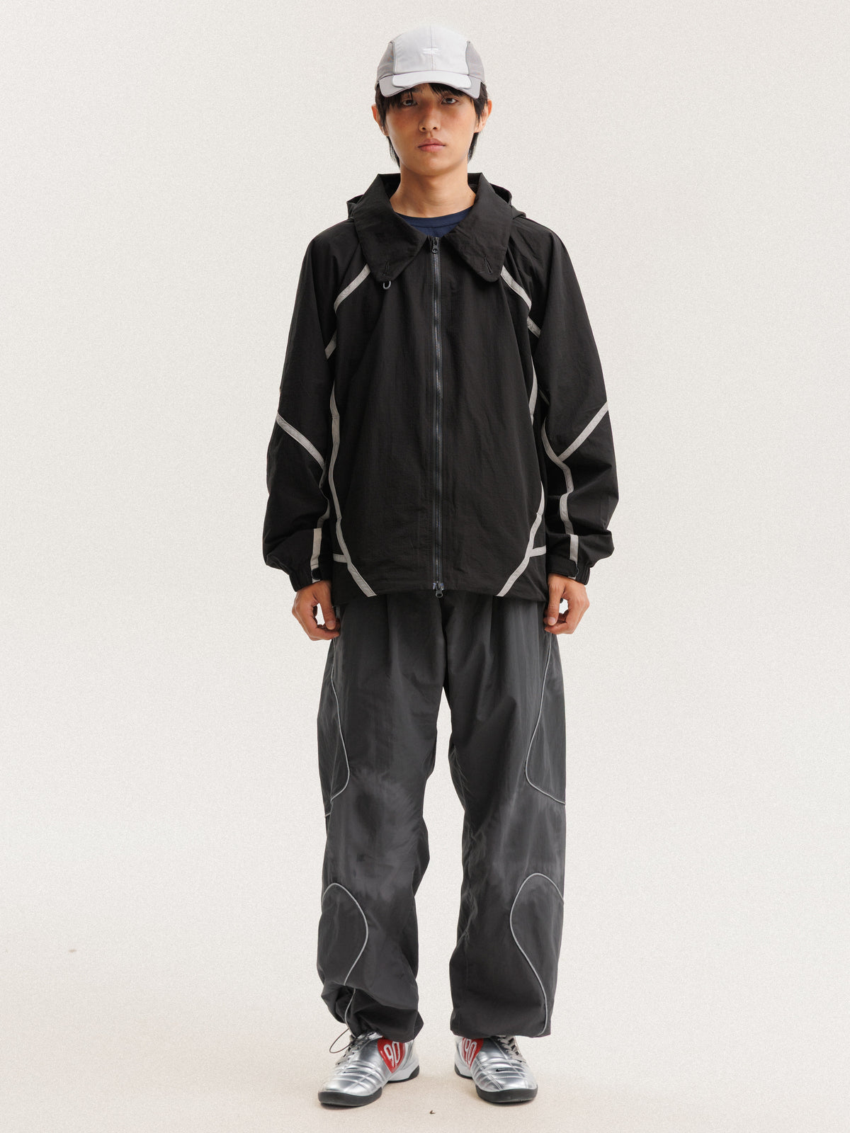 Black jacket — front view with the zip closed and curved sleeve panels visible