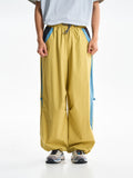 Yellow hiking pants — front view showing the drawcord waist and blue pocket trim