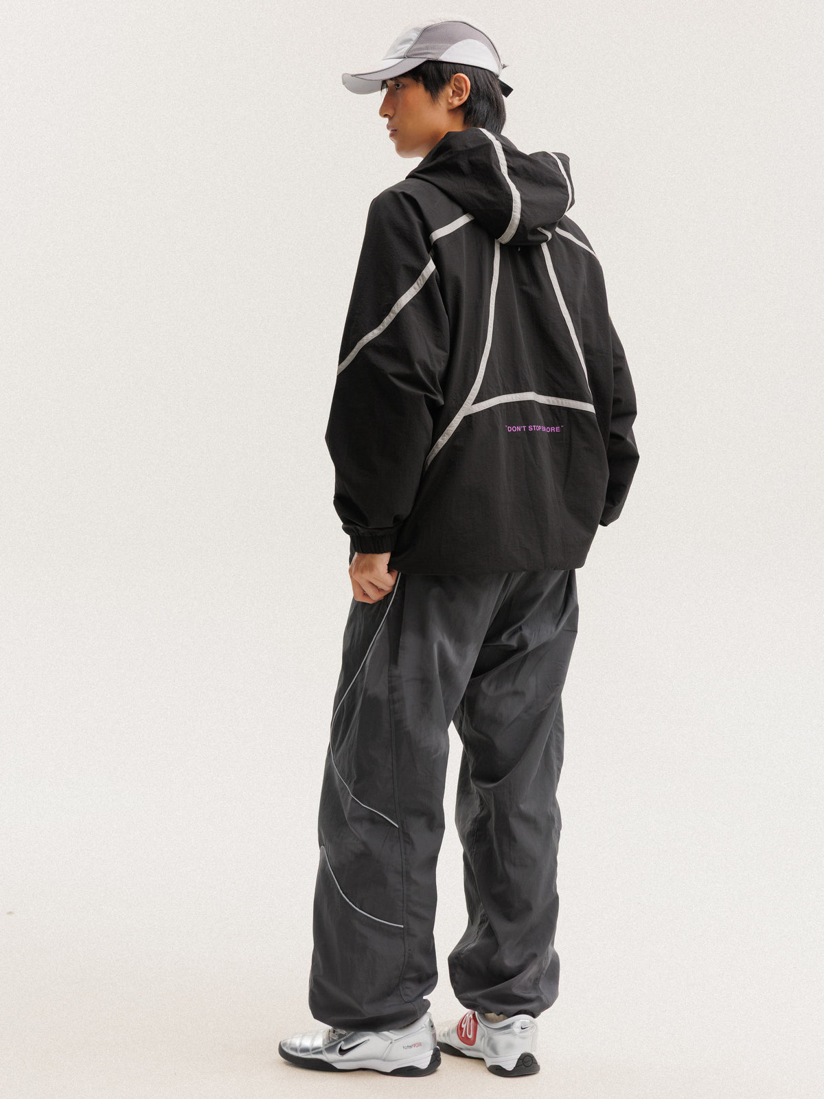 Black jacket — rear three-quarter view showing the hood and hem