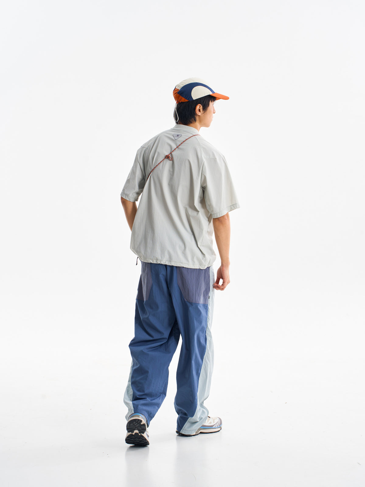 Blue hiking pants — rear three-quarter walking view showing the darker back panels