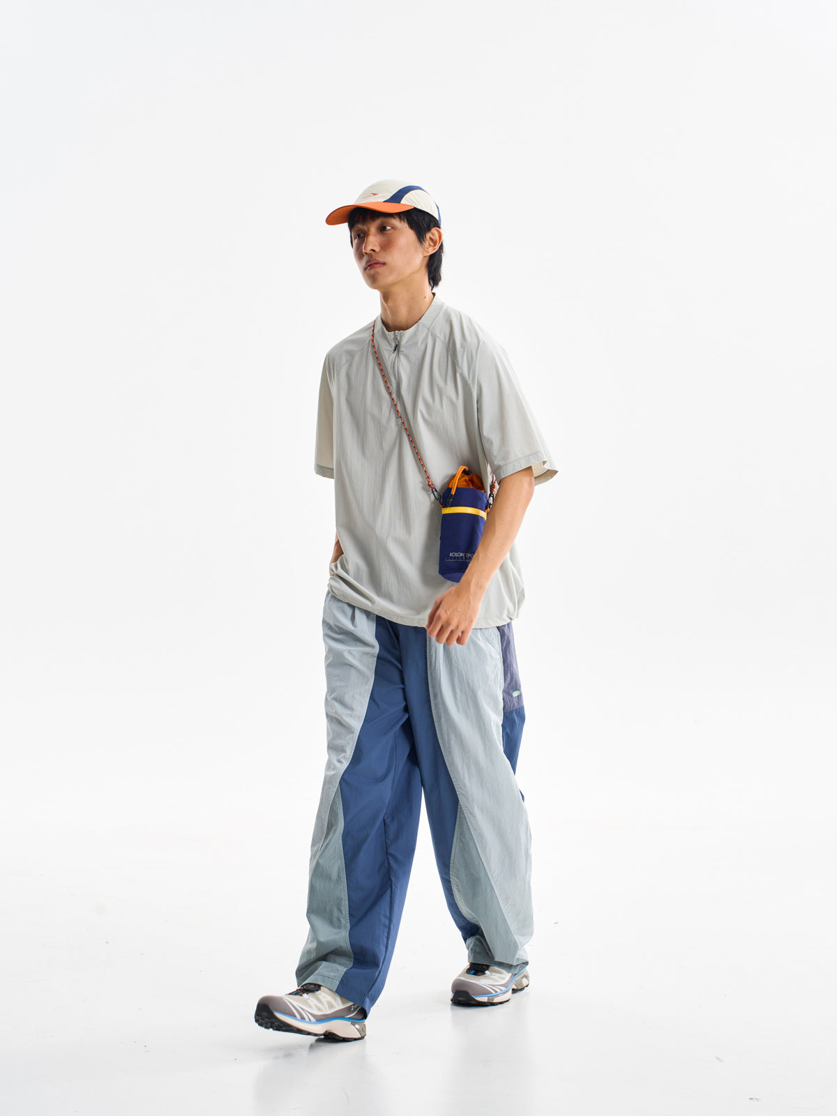 Blue hiking pants — forward stride showing the contrasting blue leg panels