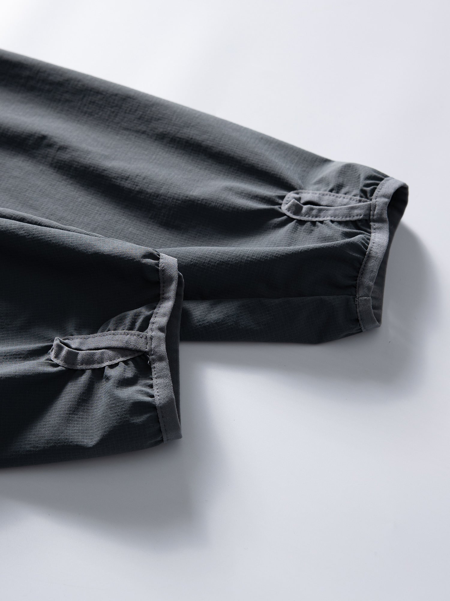 Gray jacket — paired cuffs with thumb openings and bound edges