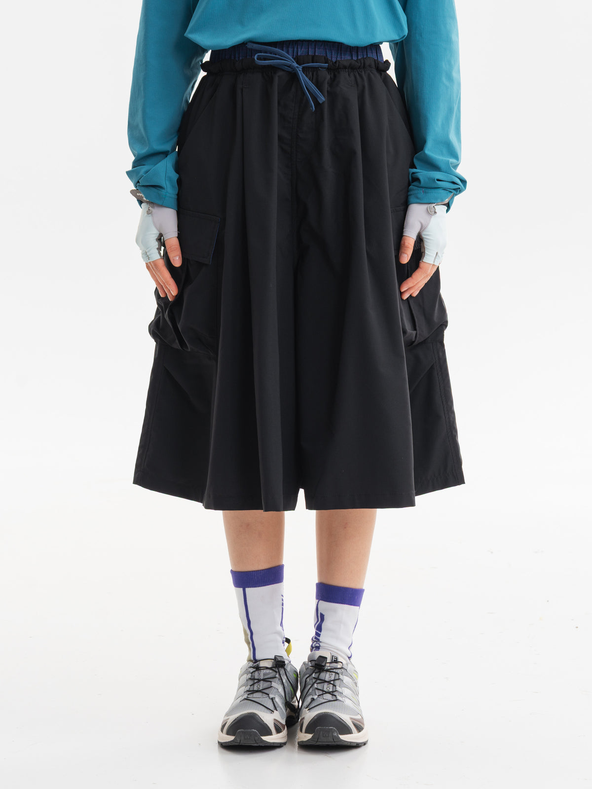 Black hiking capri pants — front view showing the blue drawcord and roomy silhouette