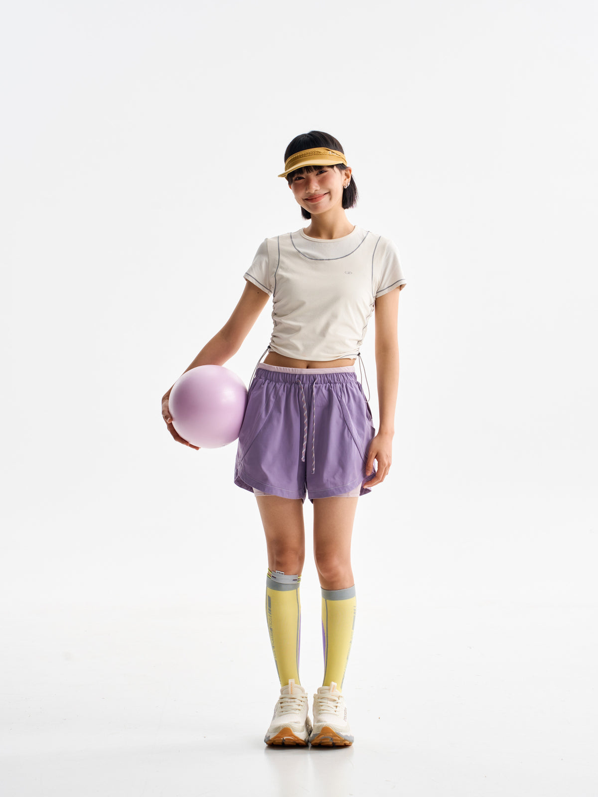 Purple hiking shorts — front view with a ball held beside the shorts