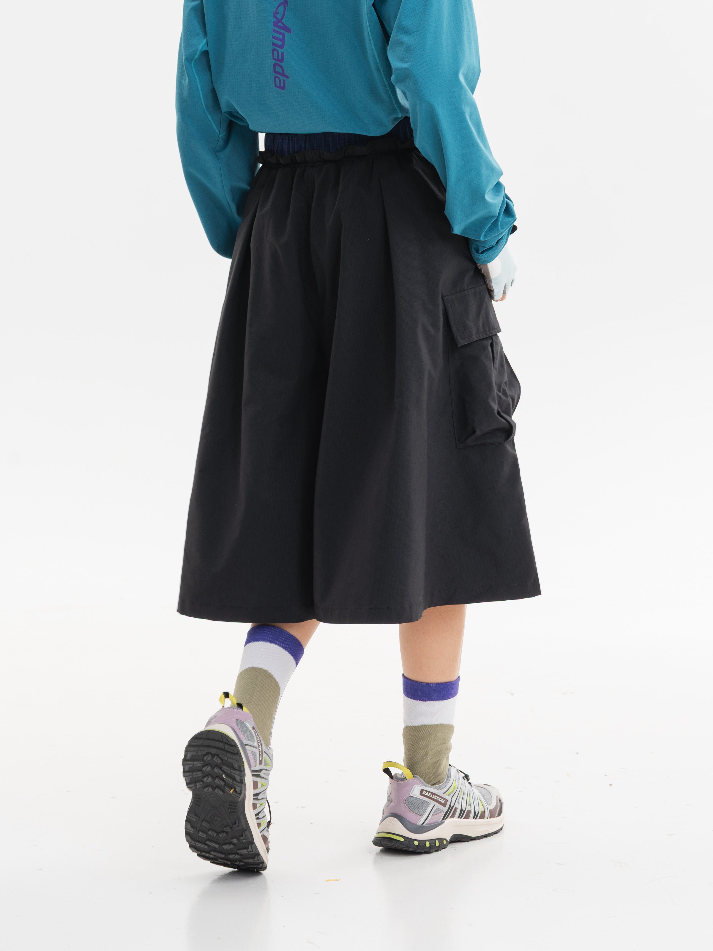 Black hiking capri pants — rear three-quarter view showing the back waist and natural folds