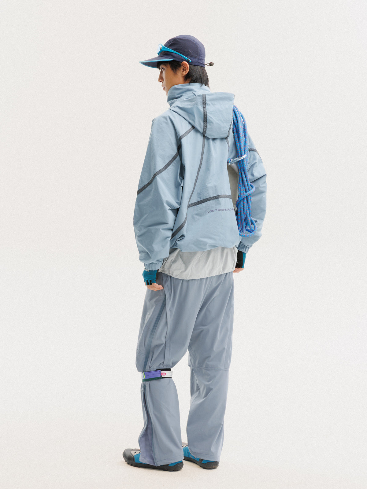 Blue jacket — rear three-quarter view showing the hood and hem