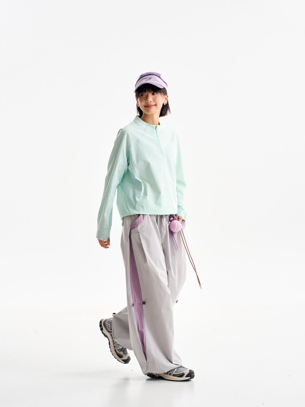 Light Gray hiking pants — walking view showing the pale legs and purple side panels