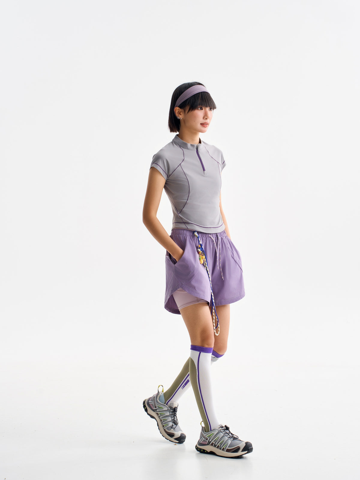 Purple hiking shorts — walking side view showing the layered construction
