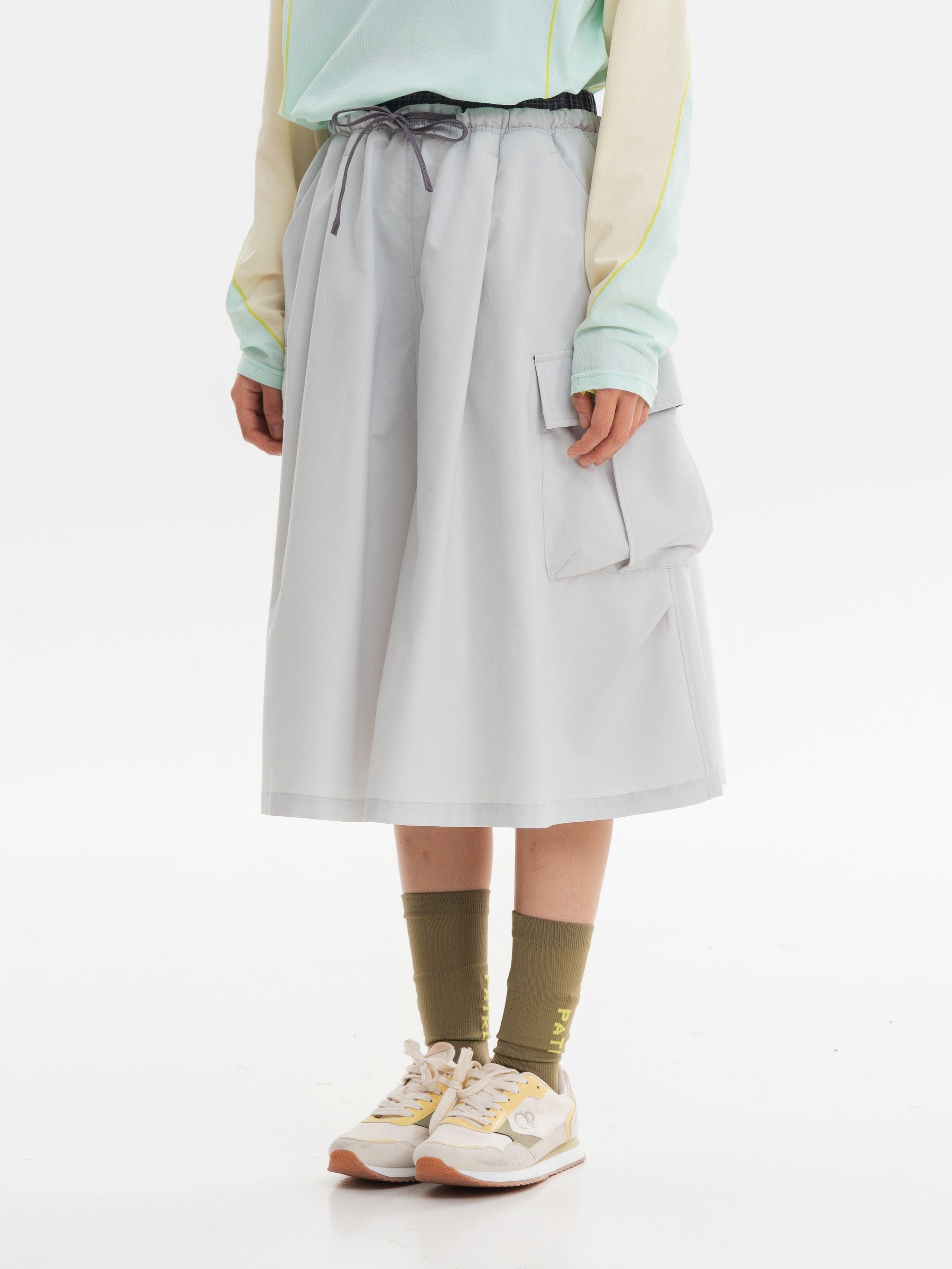 Light Gray hiking capri pants — side view showing the cargo pocket flap and pleated bag