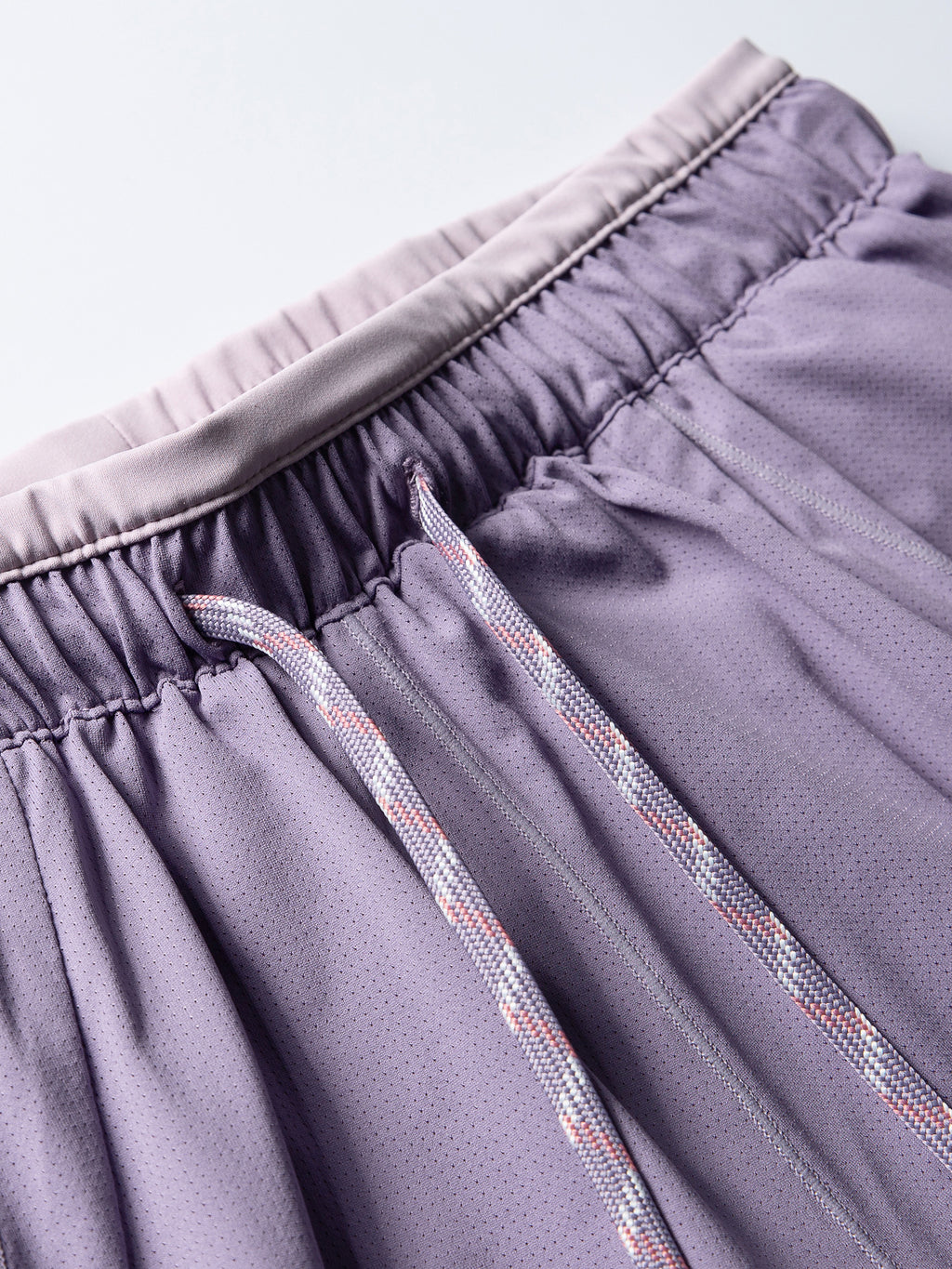 Purple hiking shorts — elastic waistband stitching and drawcord attachment