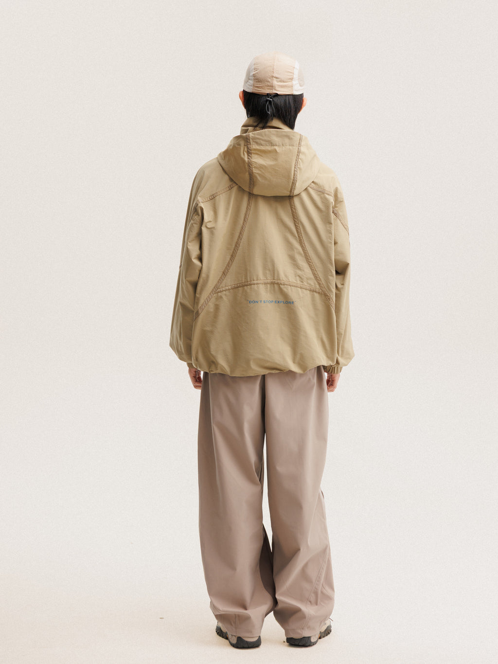 Camel jacket — rear view showing the hood and curved back seams