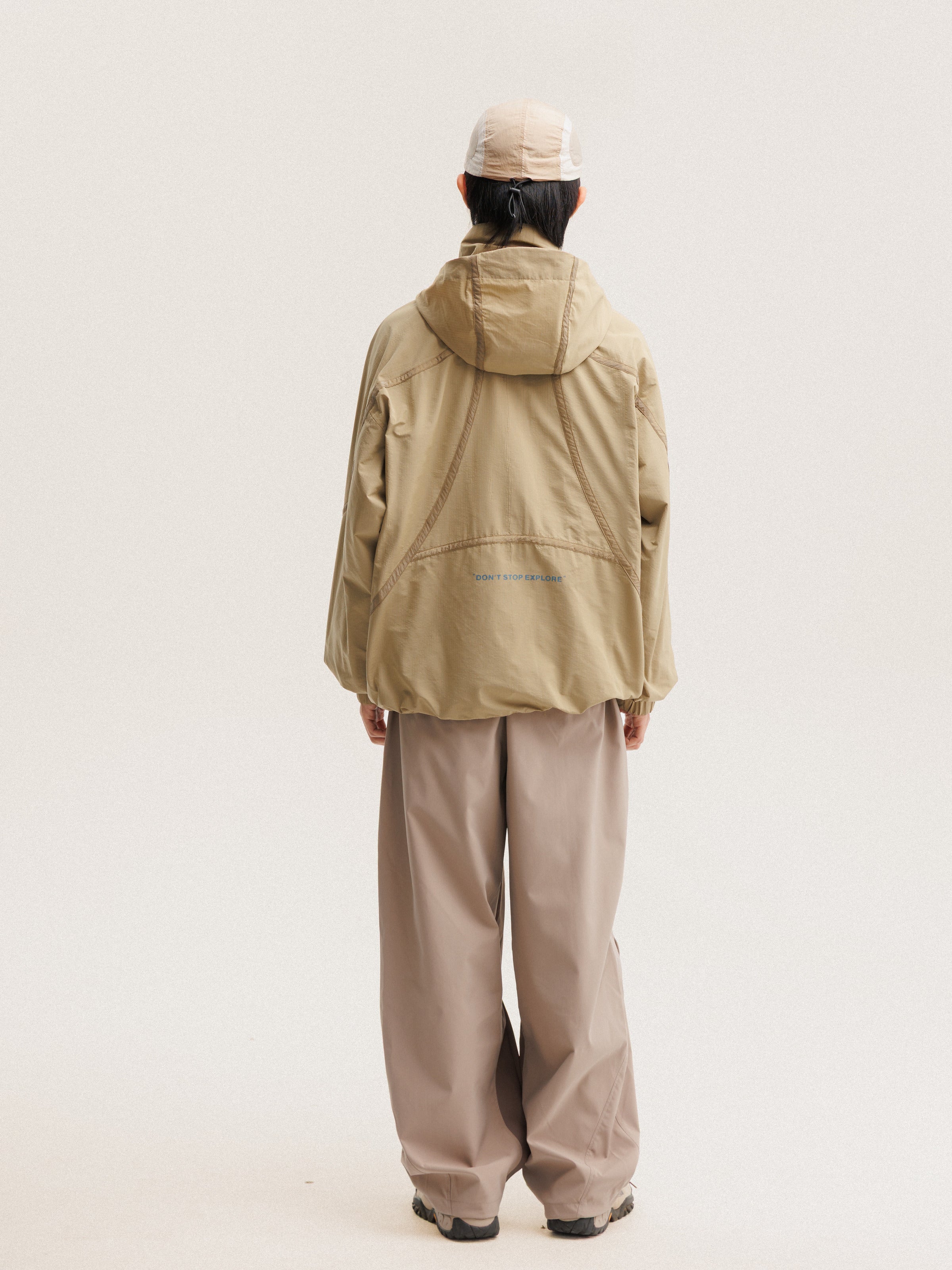Camel jacket — rear view showing the hood and curved back seams