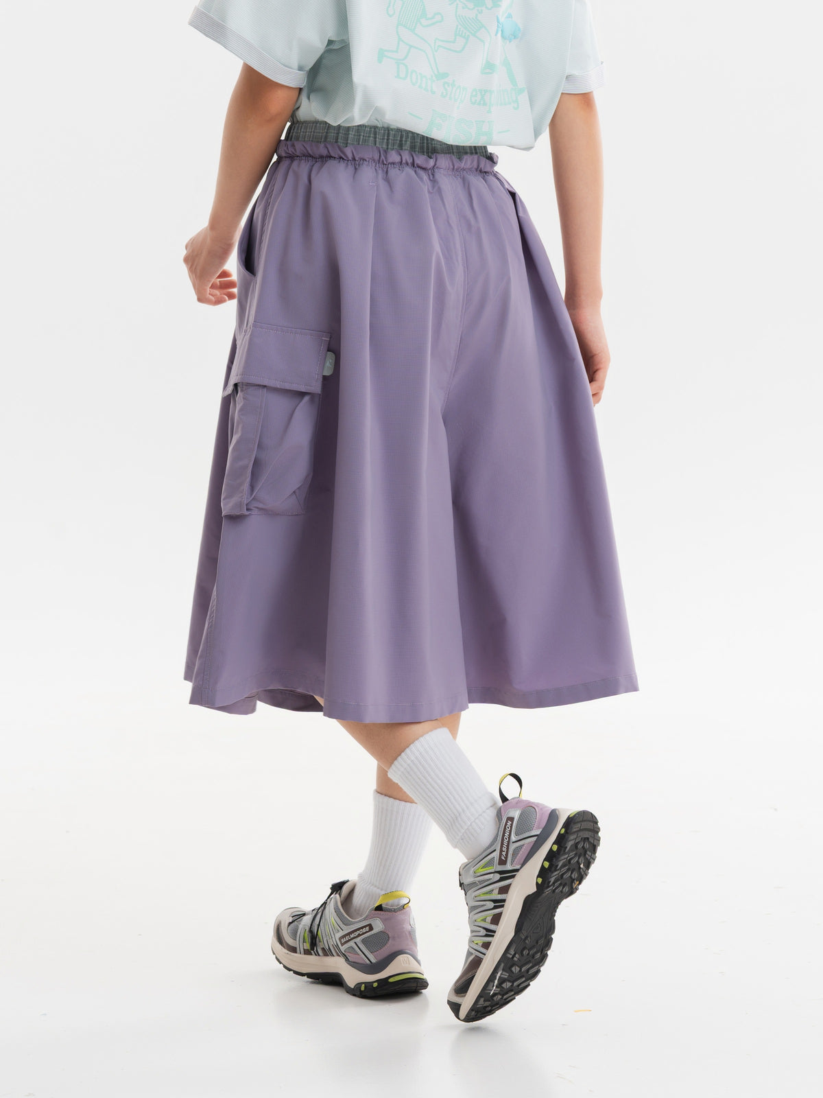 Gray Pink hiking capri pants — rear walking view showing the loose cut and vertical folds