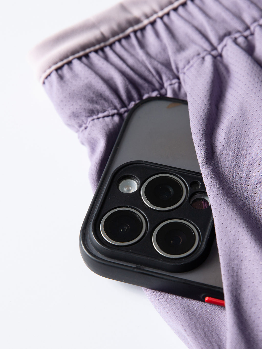 Purple hiking shorts — phone placed in the side pocket to show the opening