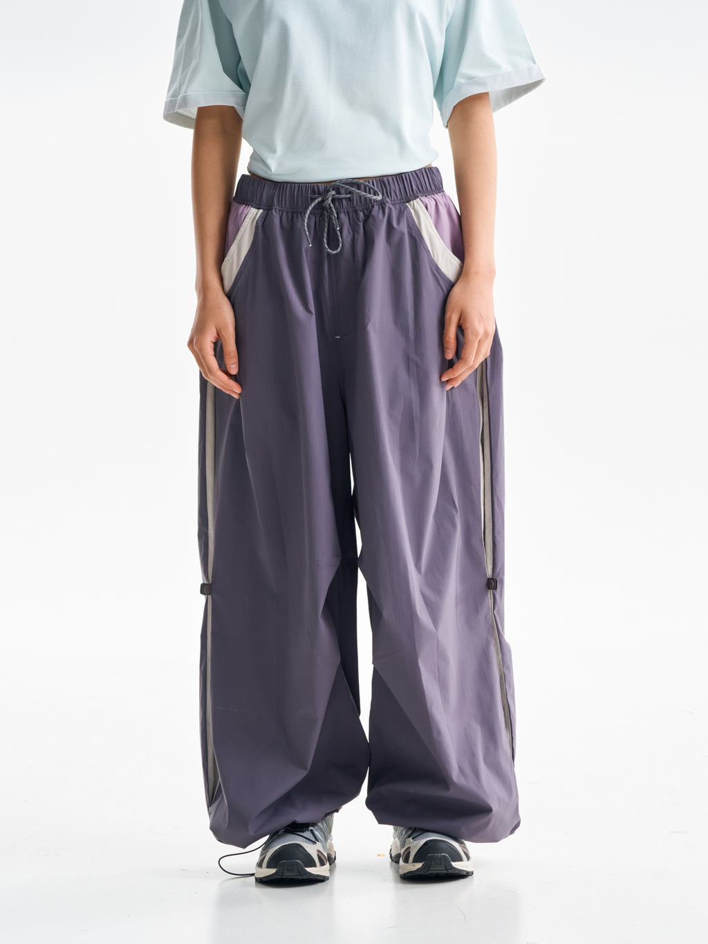 Purple hiking pants — front view showing the drawcord waist and pale pocket panels