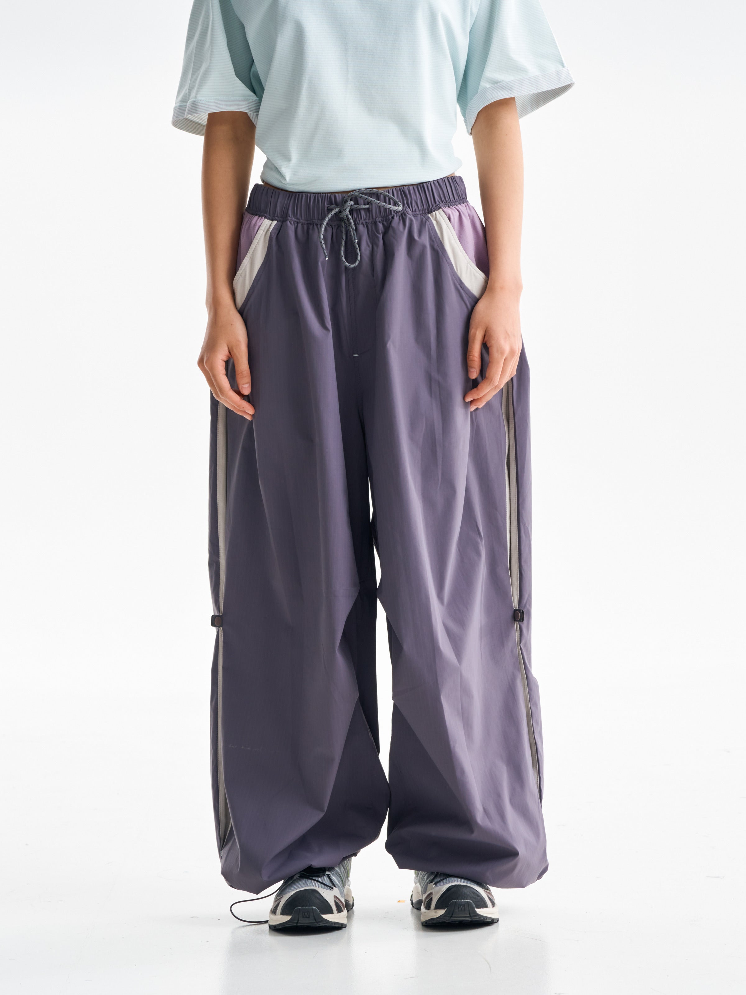 Purple hiking pants — front view showing the drawcord waist and pale pocket panels