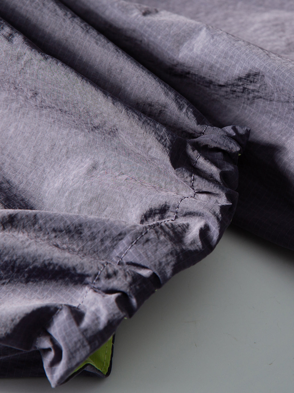 Purple hiking pants — close-up of the gathered hem seam and contrasting inner edge