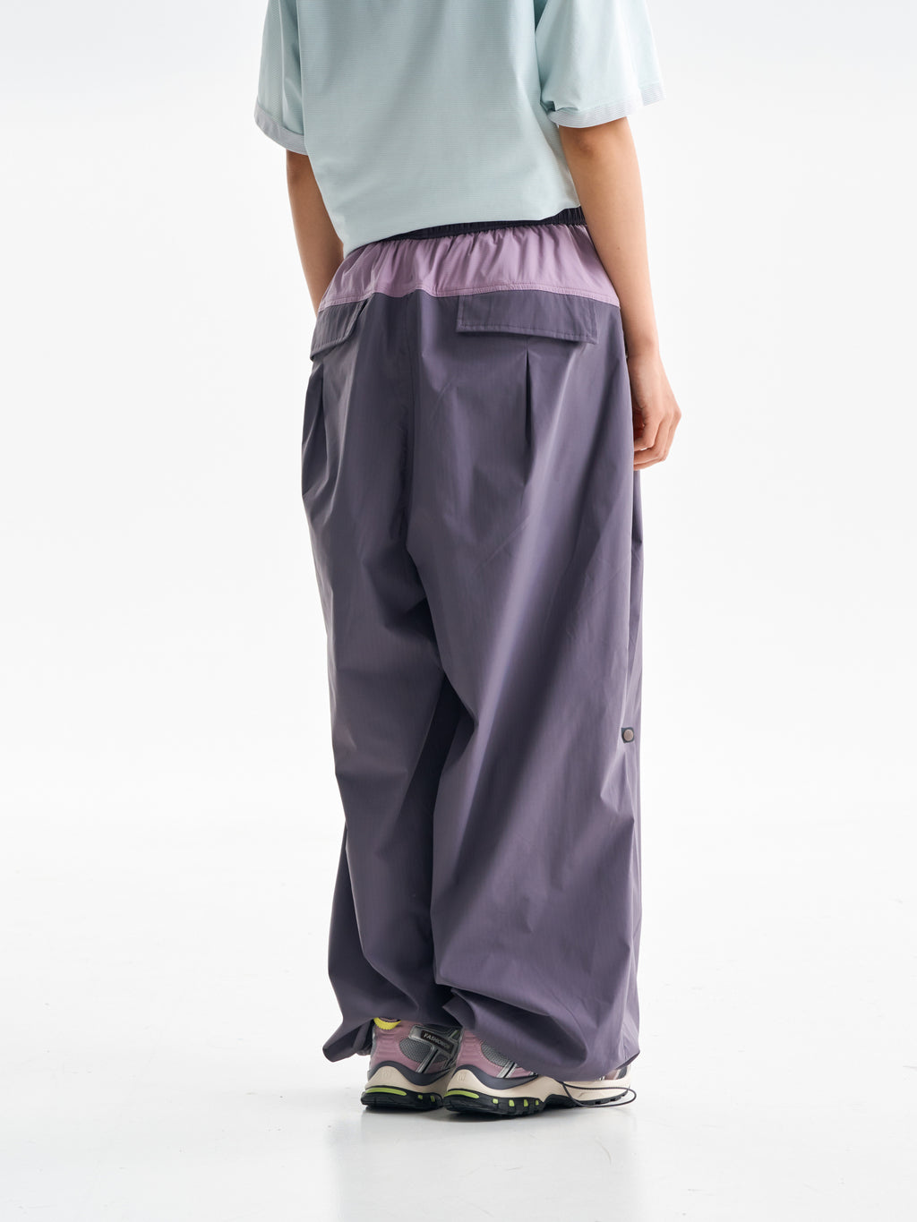 Purple hiking pants — rear view showing two flap pockets and the contrast yoke