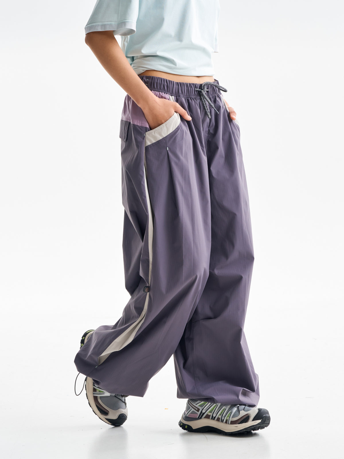 Purple hiking pants — walking side view showing the pale side panel