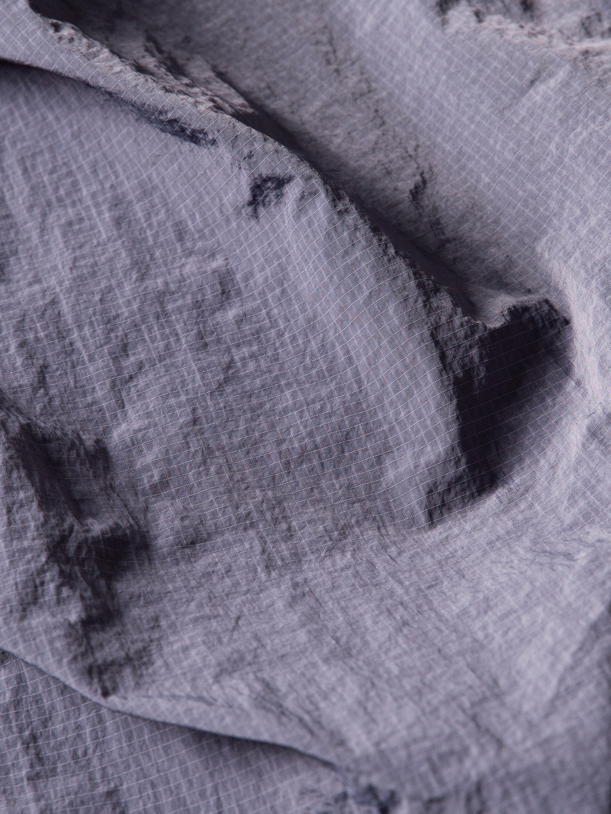 Purple hiking pants — close-up of the fine grid weave and natural fabric folds