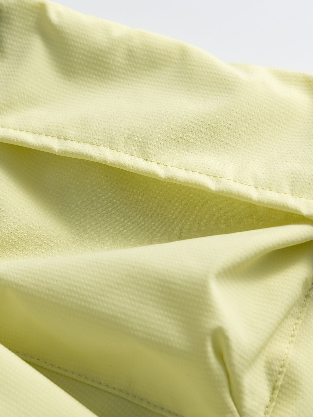 Yellow hiking capri pants — close-up of the cargo flap stitching and central pocket pleat