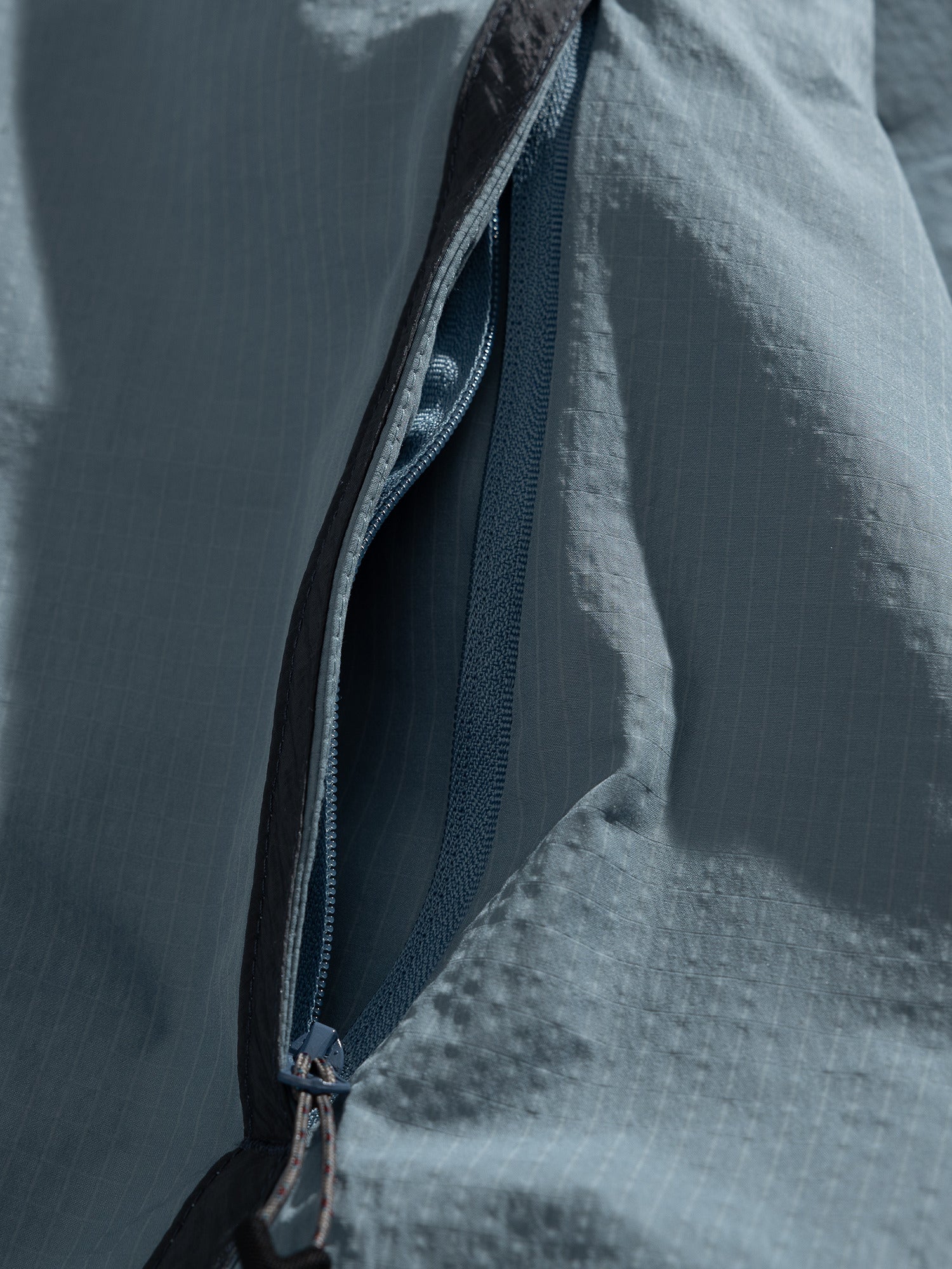 Blue jacket — open zip pocket with the zip teeth and edge stitching visible