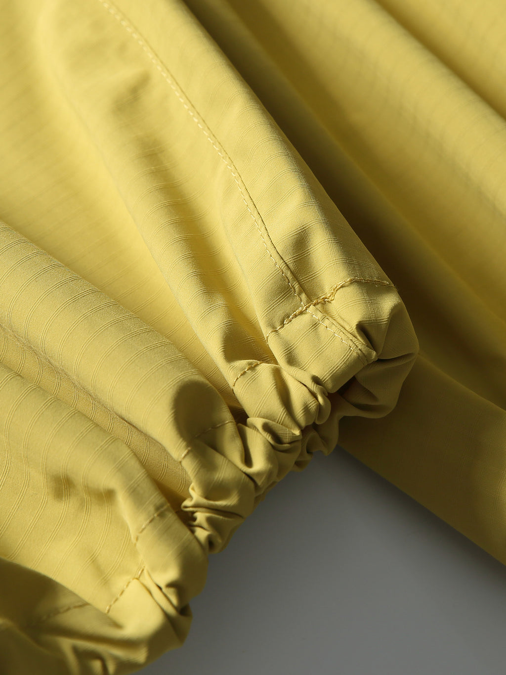 Yellow hiking pants — gathered elastic hem with stitching and folded ripstop fabric