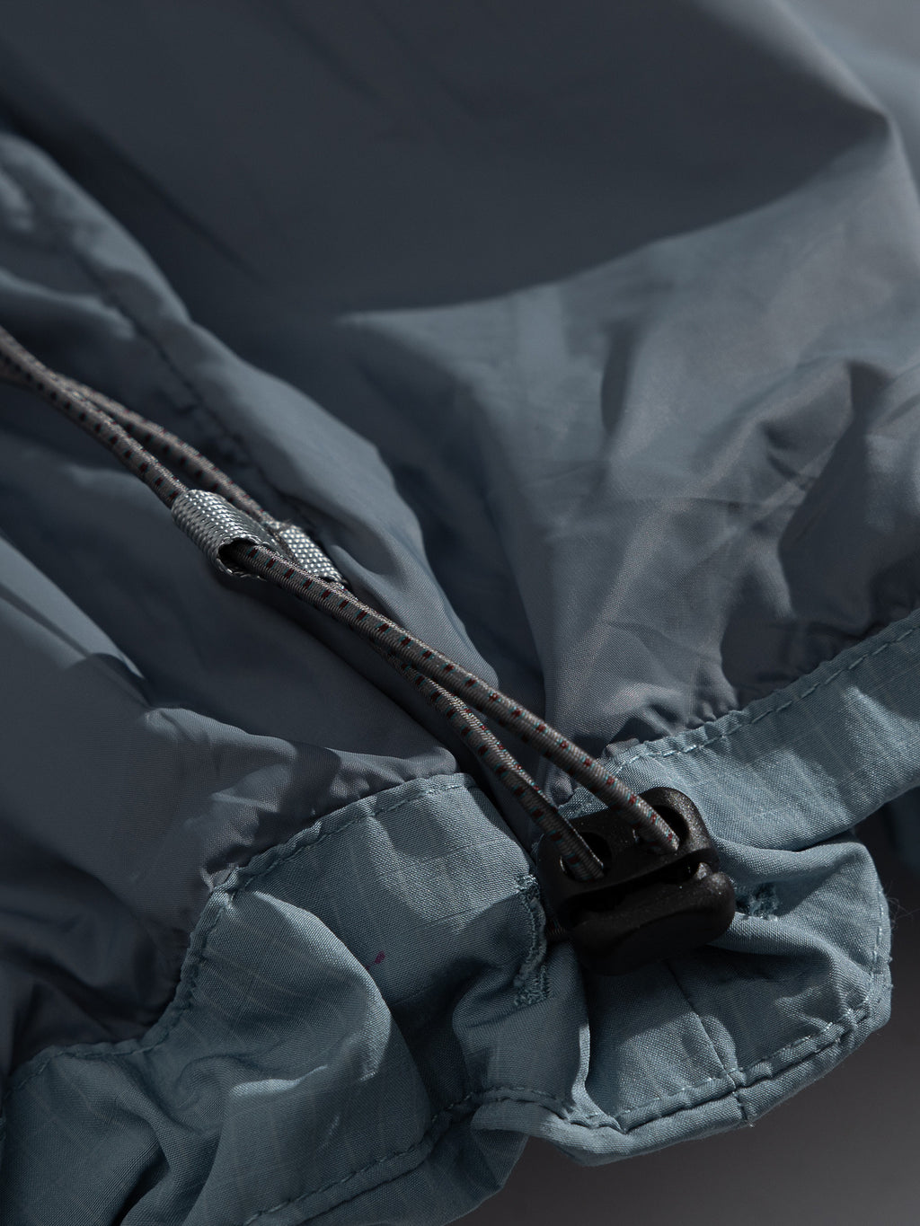 Blue jacket — hem drawcord and cord lock detail