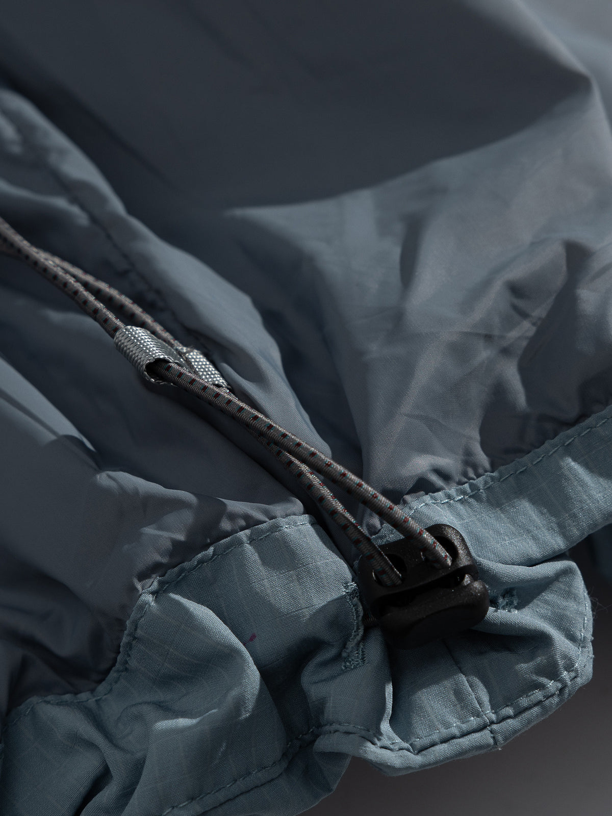 Blue jacket — hem drawcord and cord lock detail