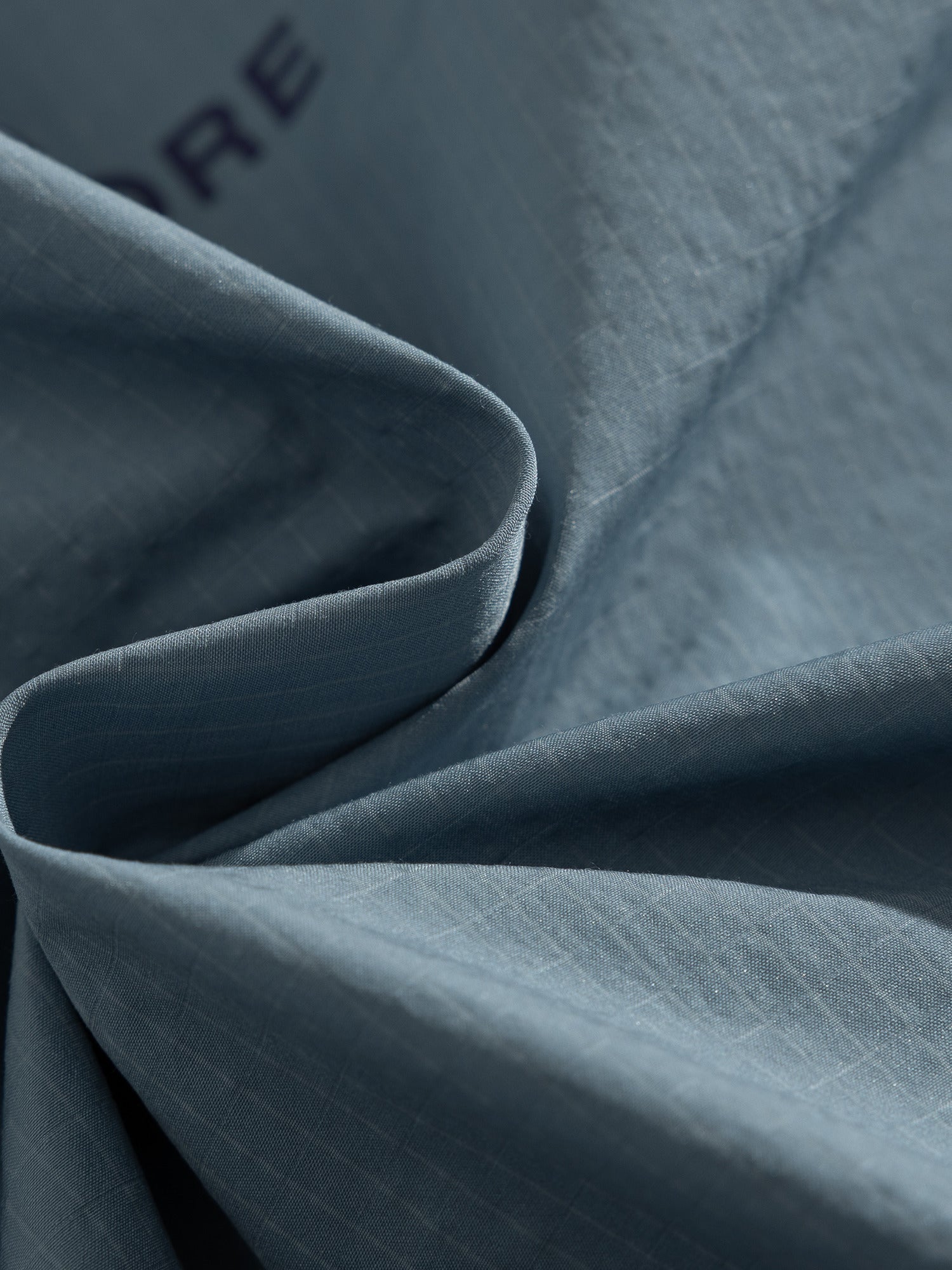 Blue jacket — folded shell fabric showing the surface texture