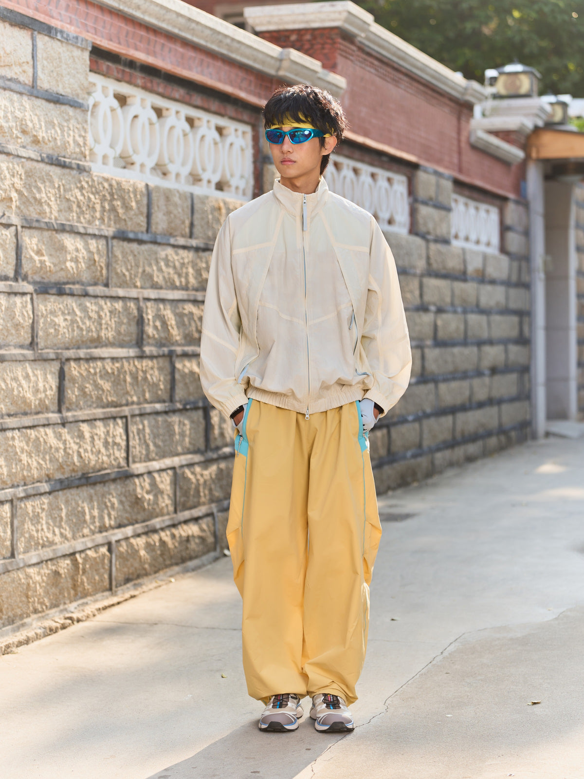 Yellow hiking pants — full-length front view outdoors with the gathered hems visible