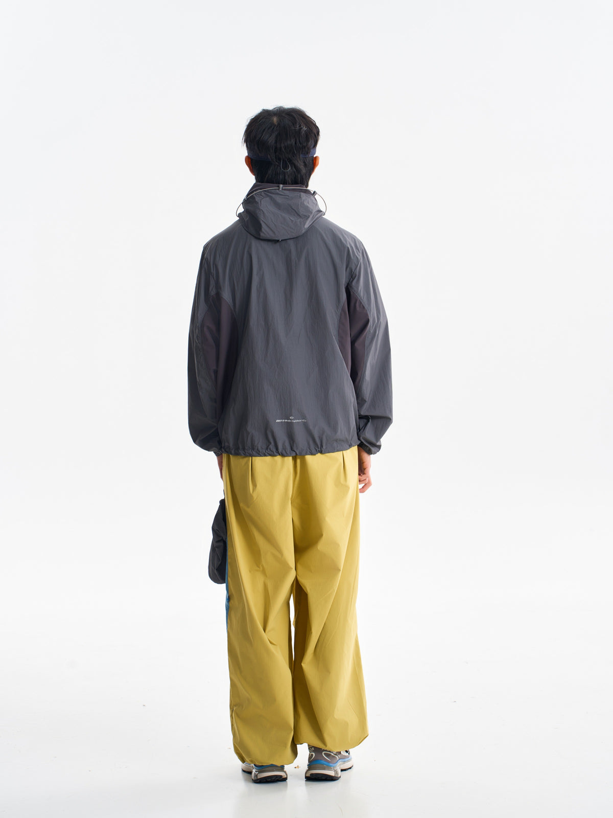 Yellow hiking pants — rear view showing the loose legs below a dark jacket