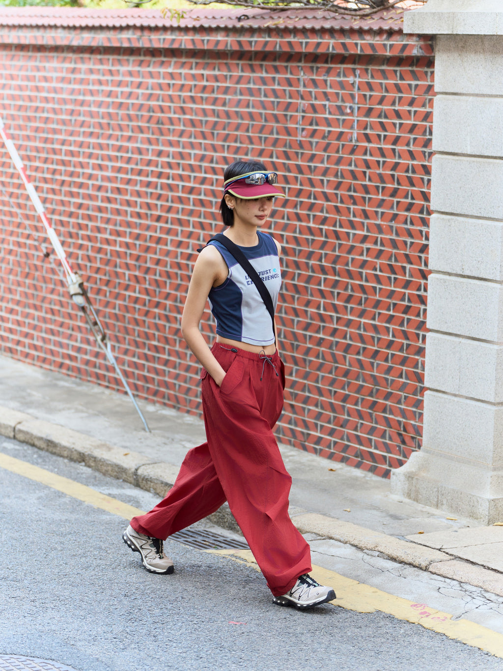 Red hiking pants — outdoor side stride showing the flowing legs and open hems